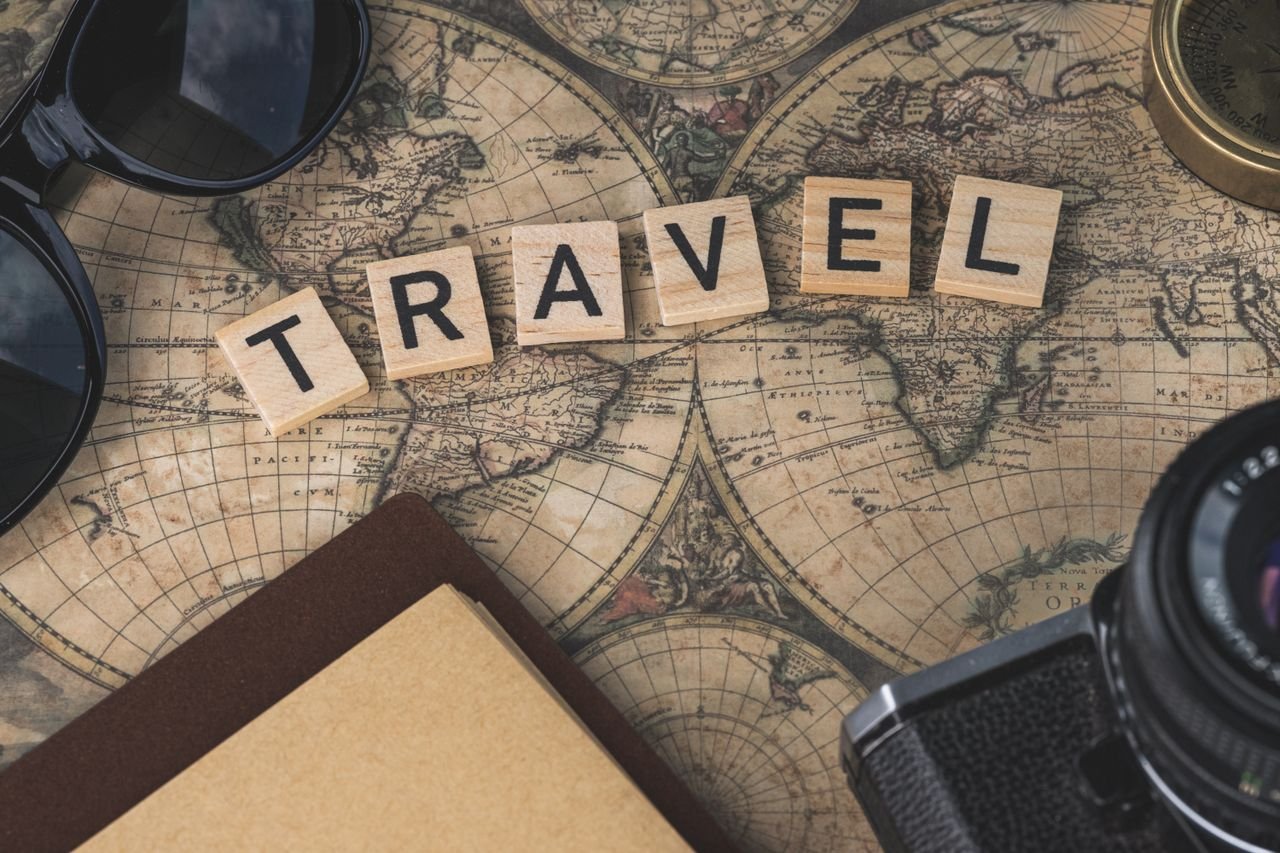 ours-journey Vintage map with travel essentials like camera and sunglasses arranged in a flat lay, perfect for adventure themes.