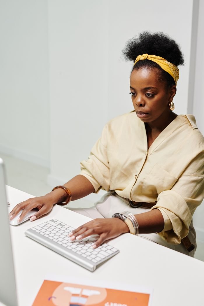 our-experience A woman intently working on her computer, embodying productivity and concentration.